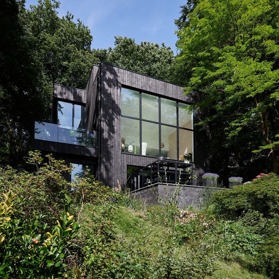 La rénovation lourde d'une villa habillée de bois brûlé sur un terrain en pente